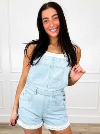 Light blue denim overall shorts with chest pocket and front button straps