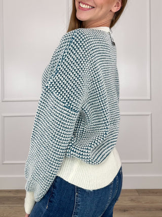 Blue-and-white textured knit long-sleeve sweater with ribbed cuffs and hem, button neckline.