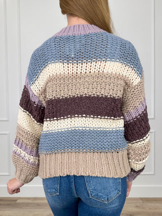 Back view: blue, cream and dark brown striped knit long-sleeve sweater