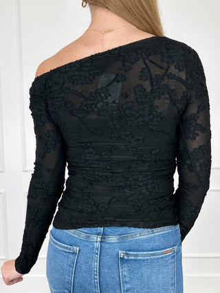 Black lace long-sleeve off-shoulder top with fitted ruched waist and sheer floral texture