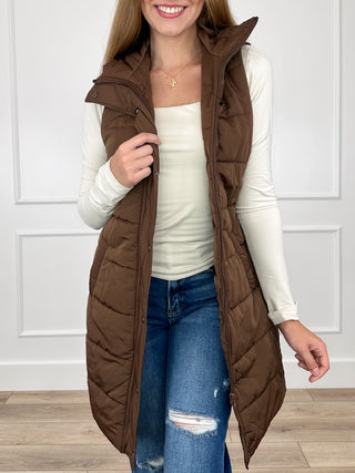 Dark brown sleeveless puffer vest with hood, quilted front and side pockets