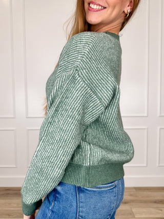 Dark green knit long-sleeve sweater top with crew neckline, side view