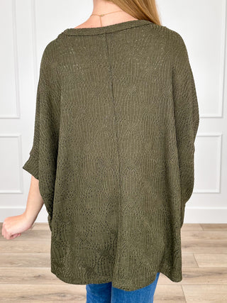 Olive green knit poncho top with back yoke and flowing, extended hem