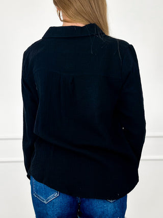 Cotton long-sleeve button-up top in black, back view with yoke seam details