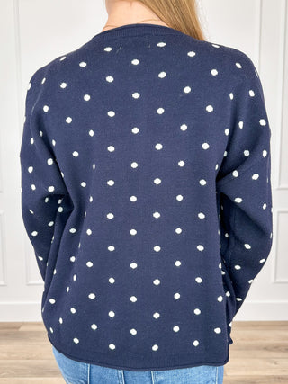 Navy knit button-up cardigan with white dot pattern, long sleeves, back view close-up