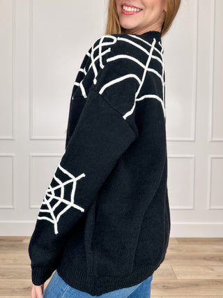Black knit button-up cardigan with white spiderweb pattern, long sleeves, button front