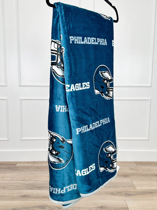 Blue Philadelphia Eagles sherpa blanket with repeated eagle helmet and text graphics