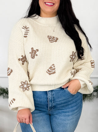 Cream knit sweater with long sleeves and gingerbread cookie graphic motifs