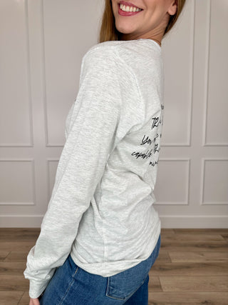 Light grey long-sleeve T-shirt with black script graphic on left sleeve