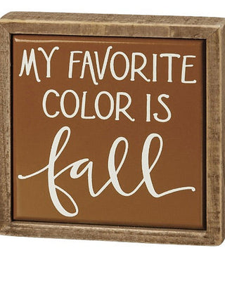 Wood shelf sitter sign with brown background and white “My favorite color is fall” lettering