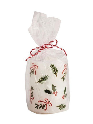 Wrapped pillar candle with red striped ribbon and holly berry pattern on white bag