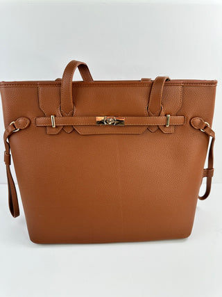 Brown faux leather tote bag with top handles, side straps, and front buckle detail