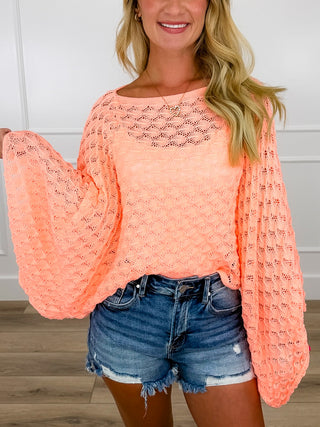 Coral cropped knit sweater top with long sleeves and diamond-pattern open knit