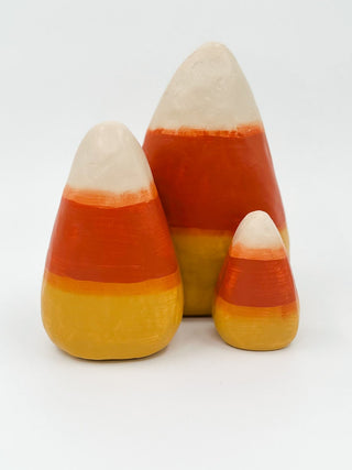 Candy corn decor set with three cone-shaped pieces in cream, orange, and yellow layers