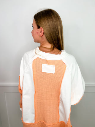 Orange long-sleeve cotton top with white contrast back panel