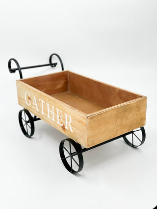 Wood wagon wall decor with black metal wheels, wooden planter marked GATHER
