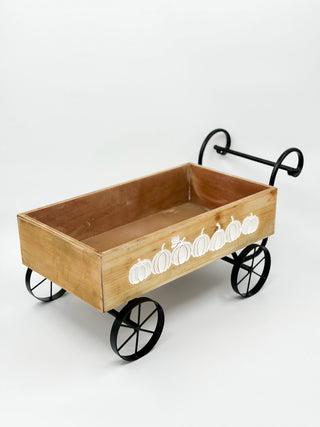Wood wagon wall decor with black metal wheels and white pumpkin border