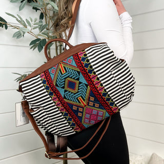 Convertible backpack bag with striped fabric, colorful geometric panel, and brown handles