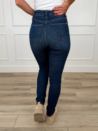 Dark wash skinny jeans with tummy control, non-distressed ankle length, back view.