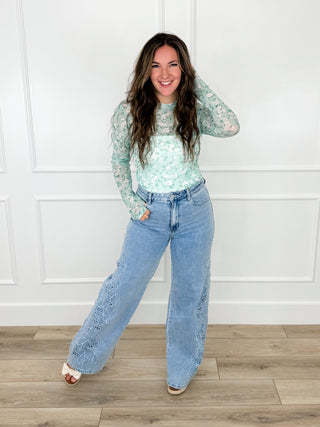 Light wash high-rise wide-leg jeans with lace embroidery along pant legs