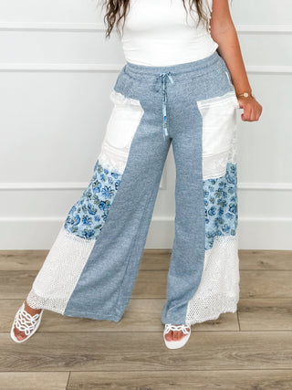 High-rise knit pants in blue with drawstring, wide legs, white lace and floral panels