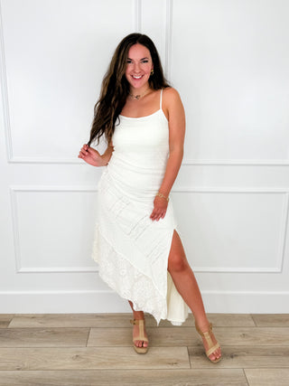 Cream knit dress with thin straps and draped asymmetrical hem with side slit