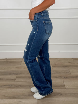 Women's straight-leg dark wash jeans with side whiskering and knee distress