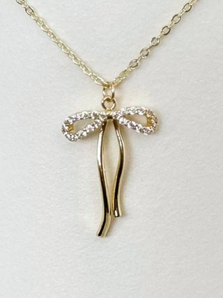 Gold-tone bow pendant necklace with dangling ribbon charms