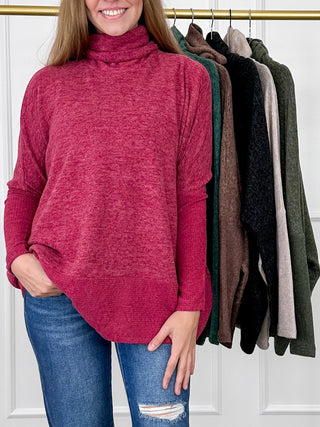Wine red knit turtleneck top with long dolman sleeves and relaxed curved hem