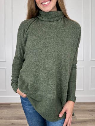 Olive green knit turtleneck top with long dolman sleeves, relaxed asymmetrical hem