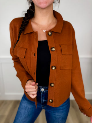 Rust-orange cropped long-sleeve button-up sweater with pointed collar and metal buttons