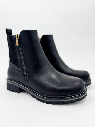 Black faux leather ankle booties with side zippers and lug soles, low block heel.