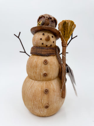Light-up snowman decor with a brown hat, woven scarf, twig arms, and broom
