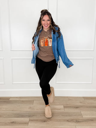 Medium wash denim jacket with long sleeves, button front, and drawstring hem