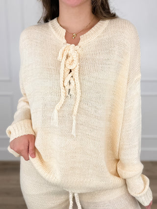 Cream knit long-sleeve sweater top with braided tassel tie at neckline