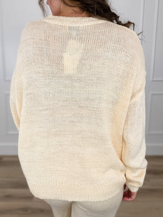 Cream knit long-sleeve sweater top, solid back panel with ribbed hem