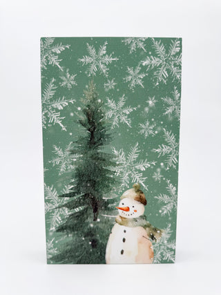 Green forest-themed shelf sitter decor with snowman figure and winter trees pattern