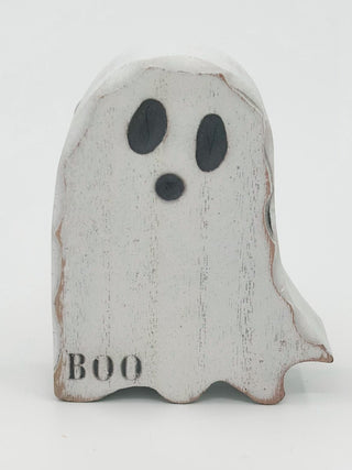 White wooden ghost decor with black eyes and mouth, 'BOO' text on front