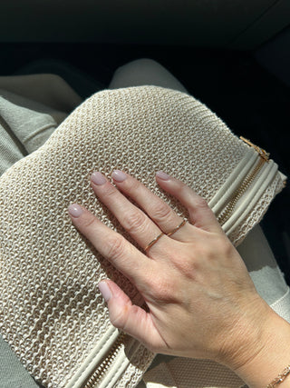 Gold-toned slim stacking ring set on finger, featuring an open center band design