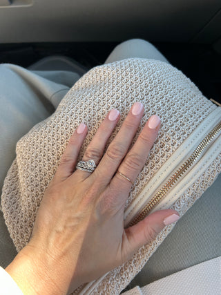 Gold-toned stacking ring with a slim band and open center detail, worn on finger