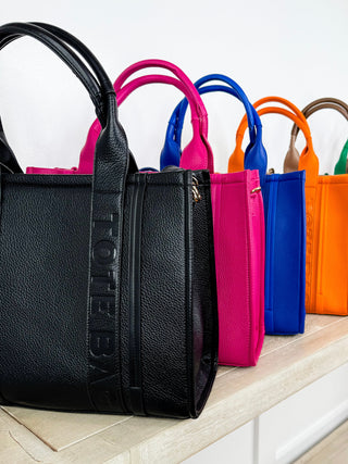 Black faux leather tote bag with top handles and matching wallet set