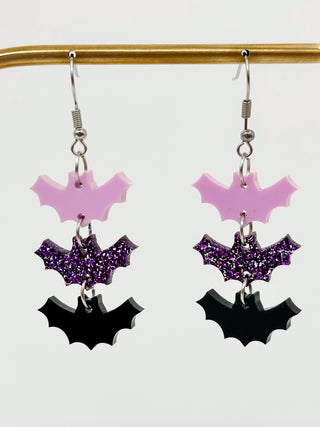 Acrylic bat drop earrings with silver hooks and three layered purple and black bat charms