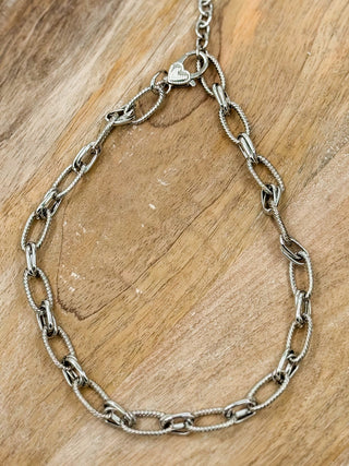 Silver chain necklace with heart-shaped link pendant and toggle clasp