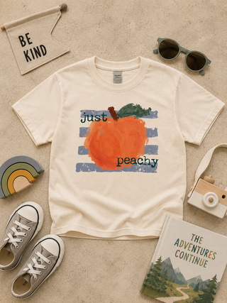 Kids cream short-sleeve graphic T-shirt with orange peach and blue brush-stroke text