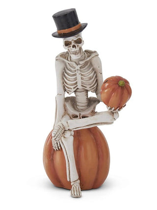 Resin skeleton decor figurine holding an orange pumpkin with black top hat