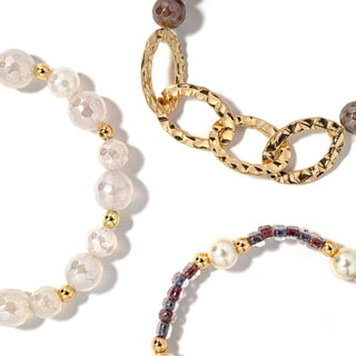 Beaded bracelet set with white beads, gold chain links, and pearl and dark bead accents