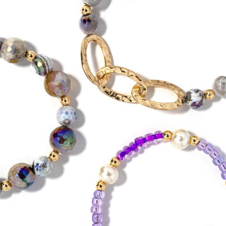 Beaded bracelet set with gray-blue beads, gold chain links, and purple beaded bracelet