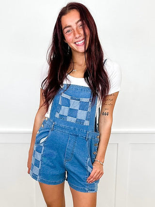 Denim patchwork romper with front bib, short overalls-style legs, medium wash