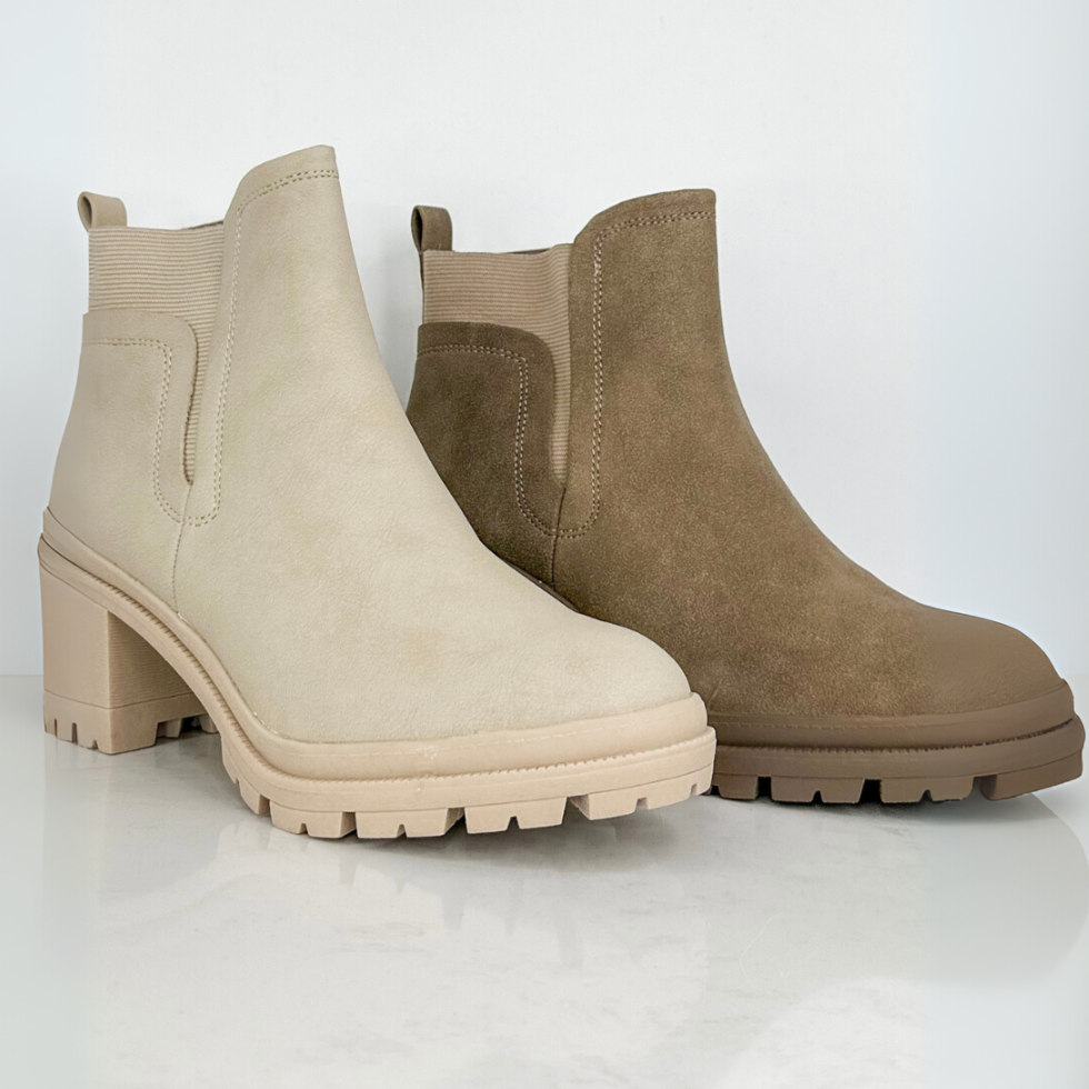 Pair of beige and brown ankle boots on a white background