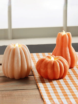 Pumpkin-shaped LED candles in cream and orange, with ribbed tops